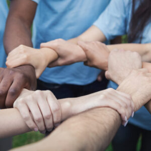 Hands of young people join in circle, making chain, volunteers unite to save the world, copy space